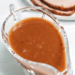 A gravy boat filled with brown gravy.