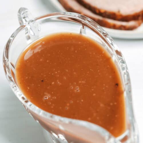 A gravy boat filled with brown gravy.