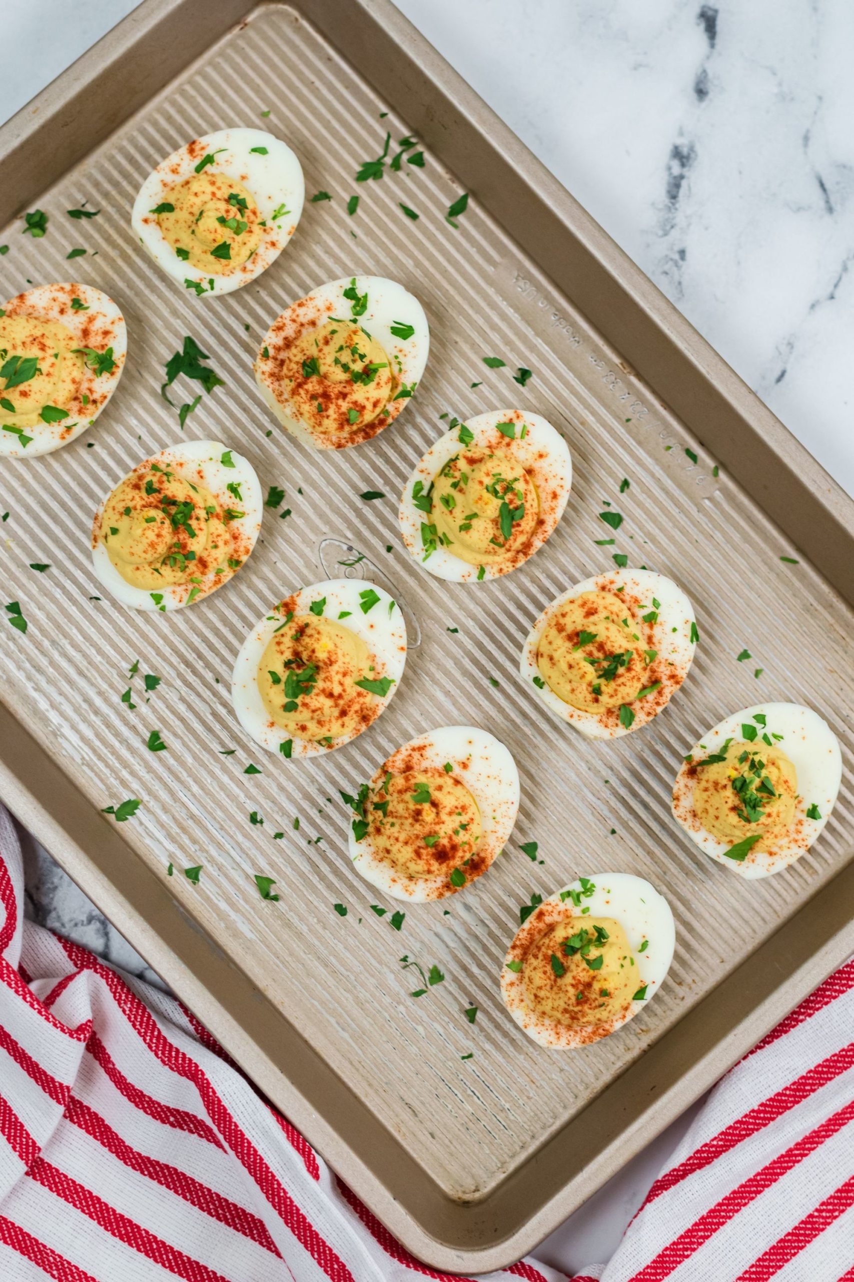 Hummus Deviled Eggs on a tray. sprinkled with herbs.
