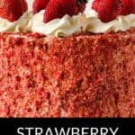 A delicious Strawberry Crunch Cake Recipe topped with whole strawberries and swirls of whipped cream, finished with a crumbly red coating on the sides.
