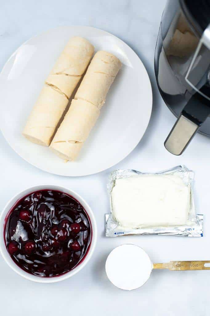 Pastry and fruit next to an air fryer.