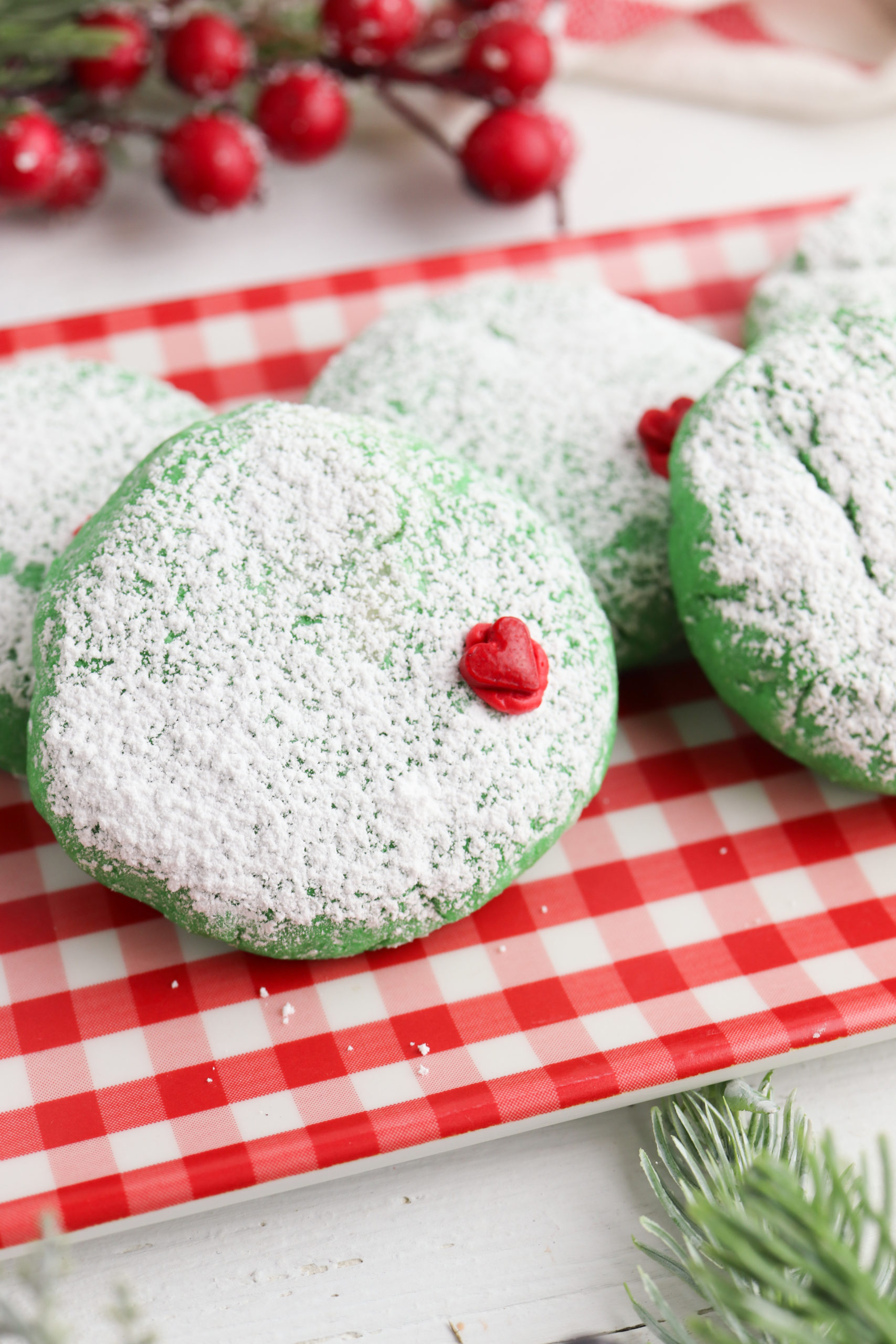 Grinch cookies on a red and white check platter.