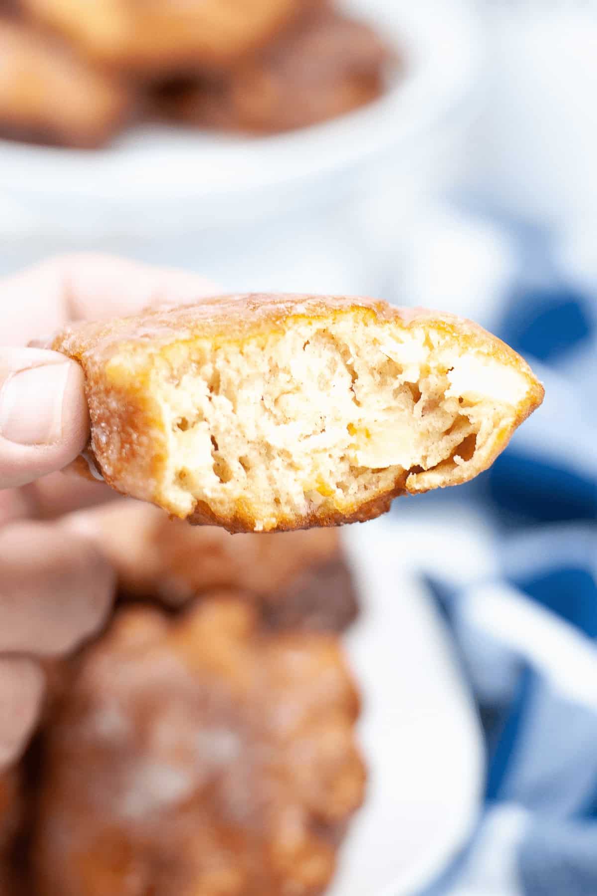 A hand showing a bite taken out of the dessert.