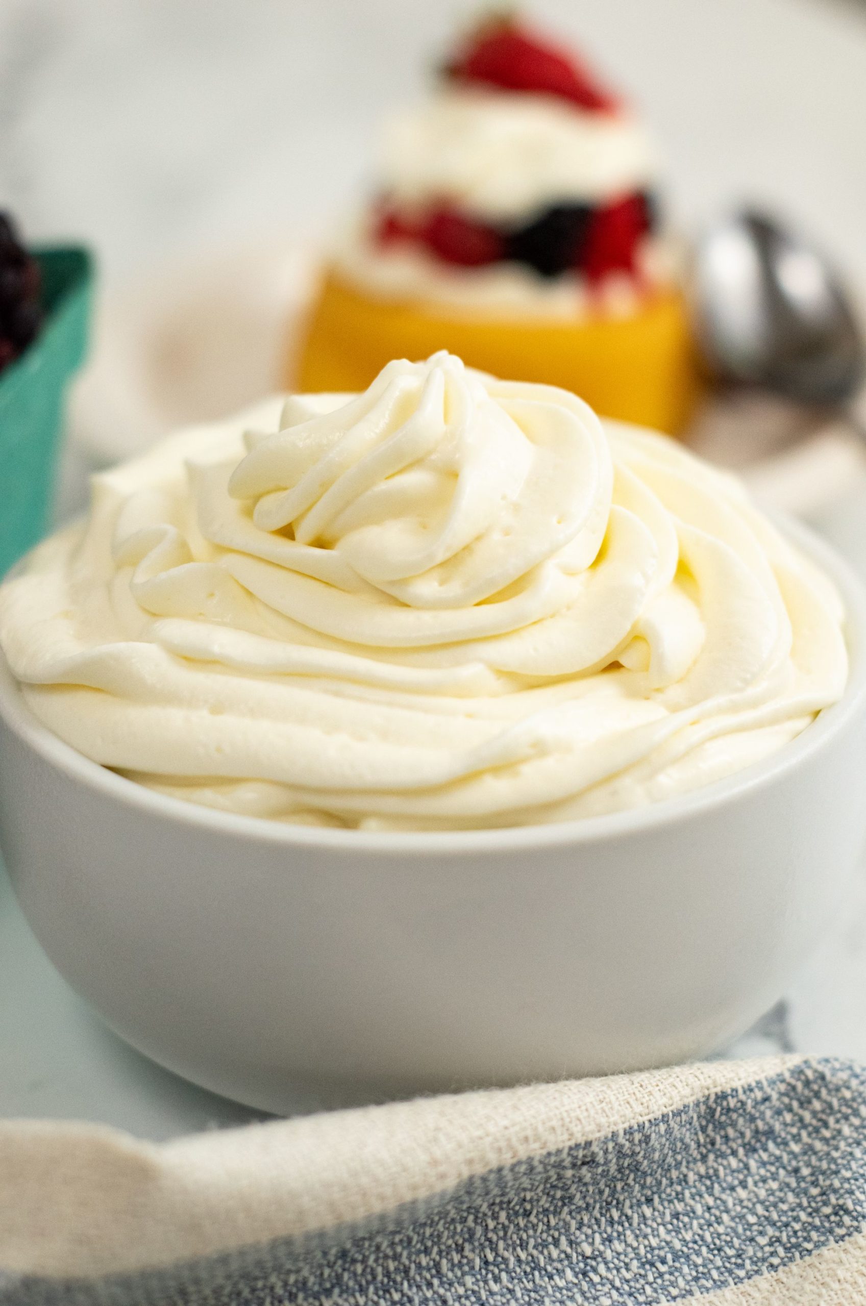 White bowl filled with whipped cream on a marble table.