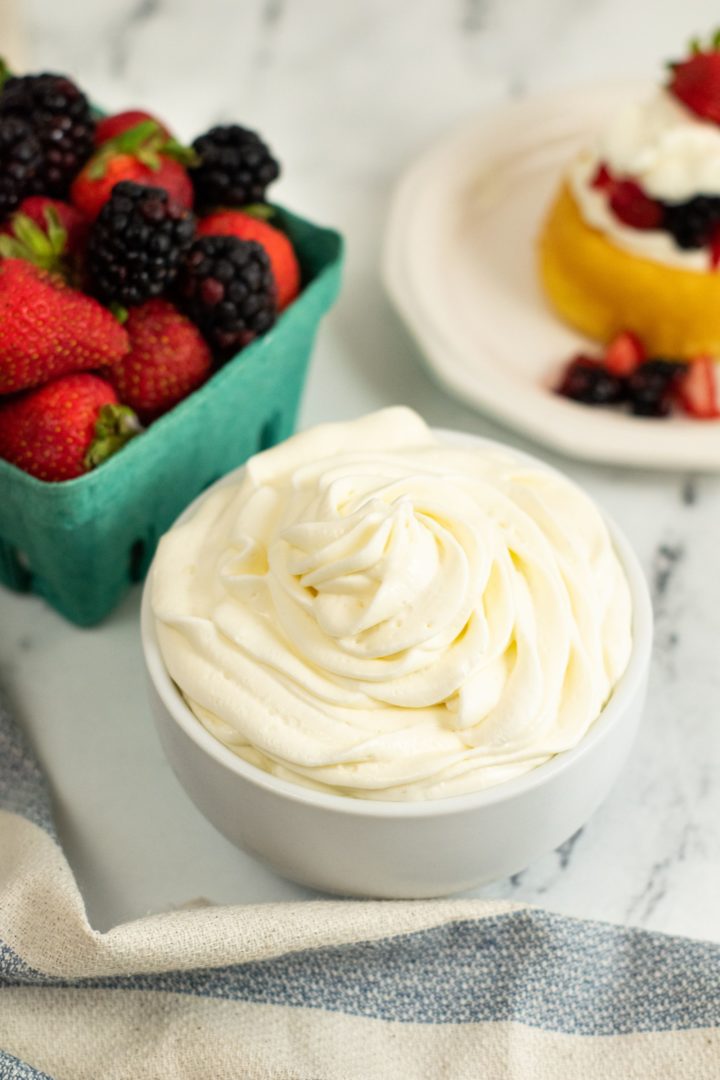 Whipped cream with a side of berries and with pie.