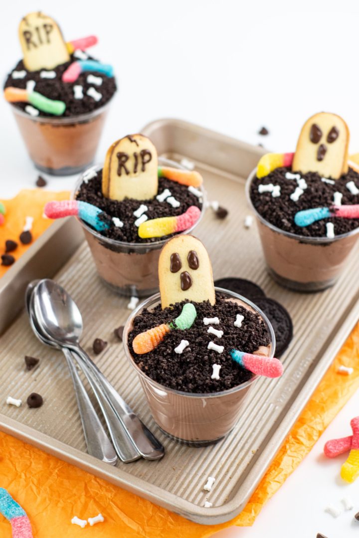 4 halloween pudding cups on a tray with spoons