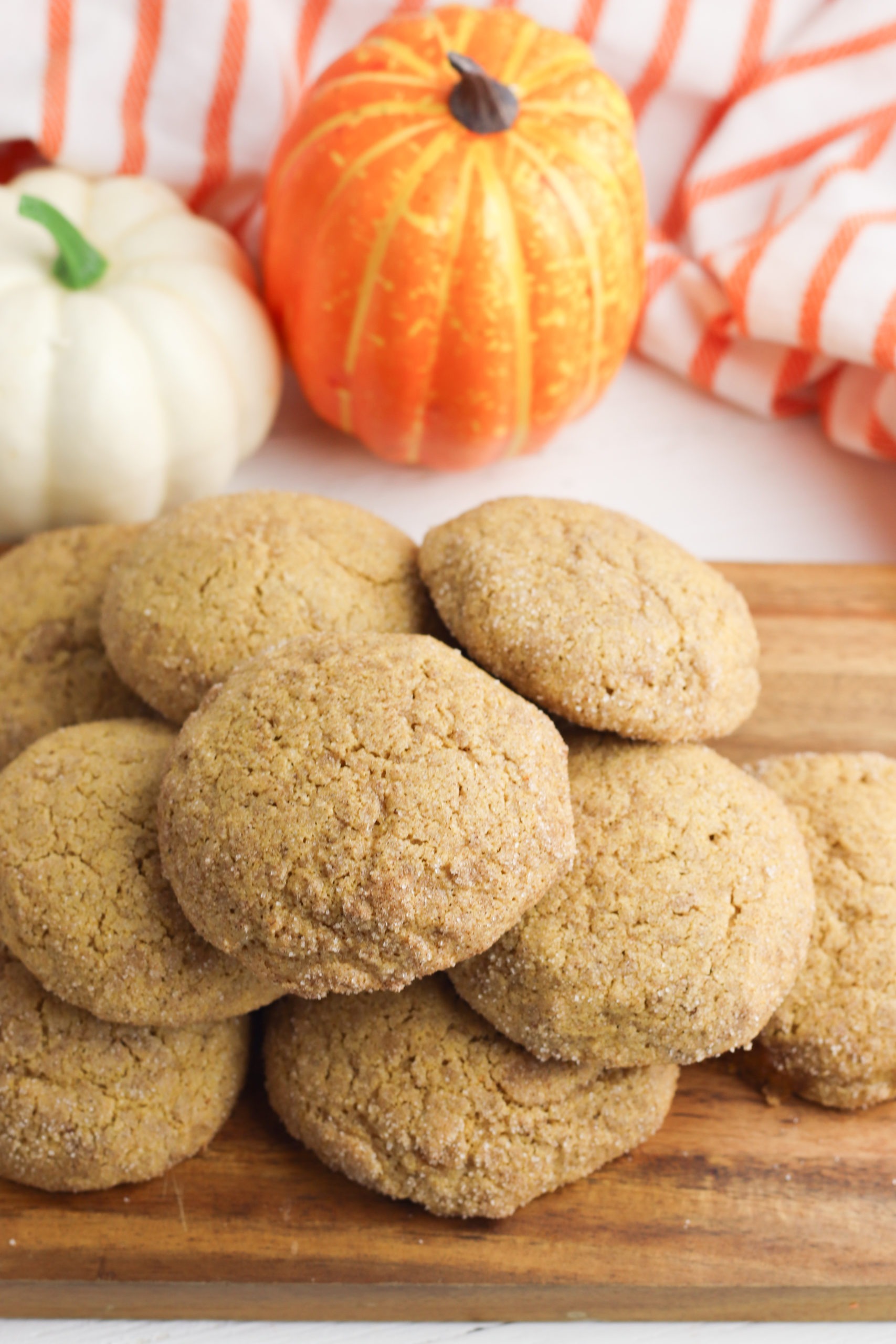 Pumpkin Spice cookies with pumpkins on the side with an orange and white stripped napkin.