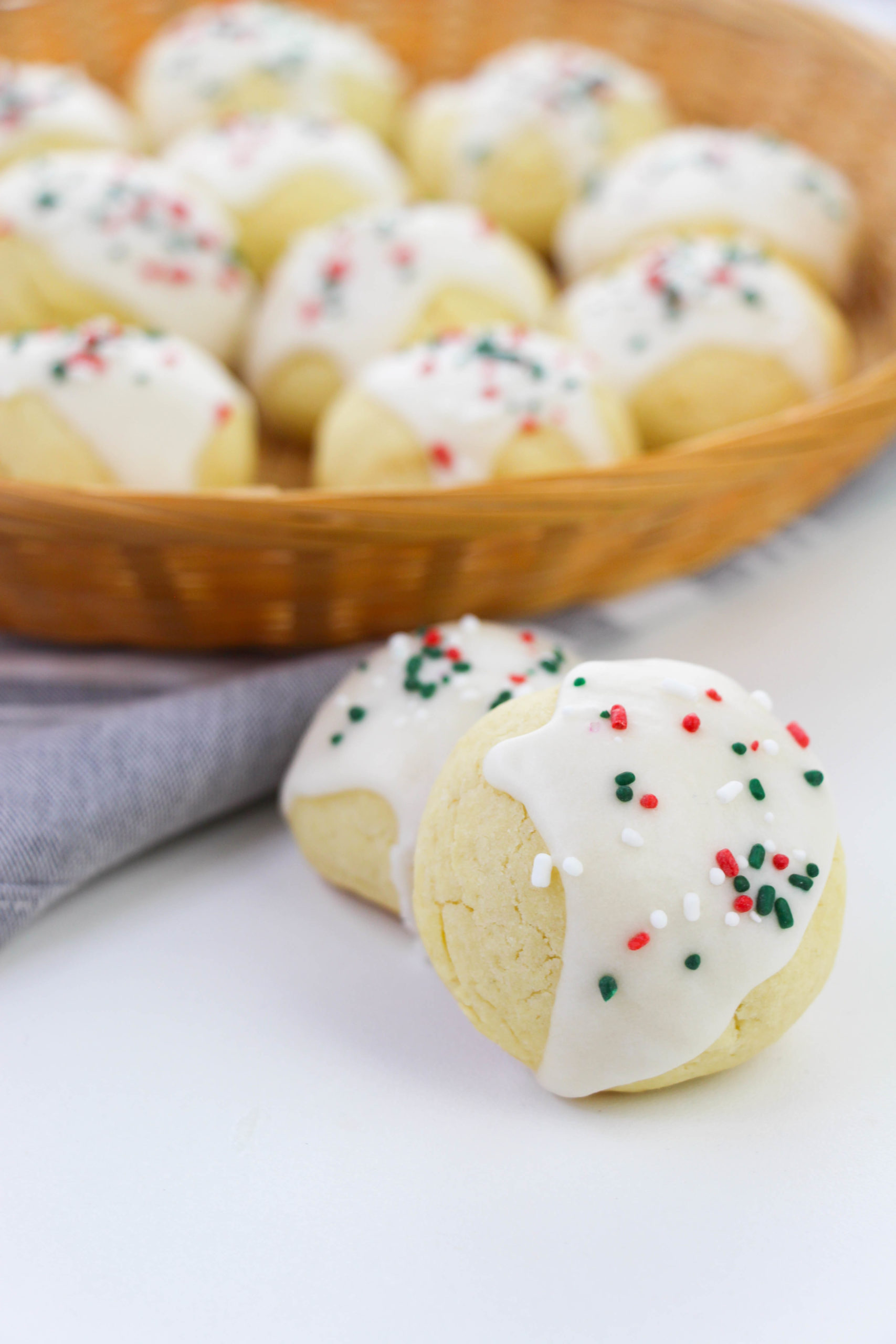 Two Italian Wedding Cookies outside a bowl of additional cookies.