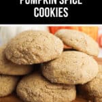 A stack of chewy pumpkin spice cookies sits invitingly on a wooden board, exuding warmth and coziness.
