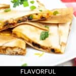 A plate of shredded chicken quesadilla is artfully garnished with sour cream and fresh cilantro, elegantly presented on a white dish.