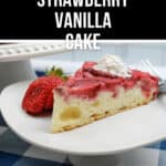 A slice of Upside Down Strawberry Vanilla Cake with a dollop of whipped cream and a whole strawberry on a white plate.