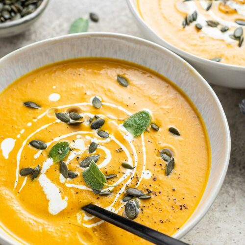 pumpkin soup with apple and spices in a bowl with garnish