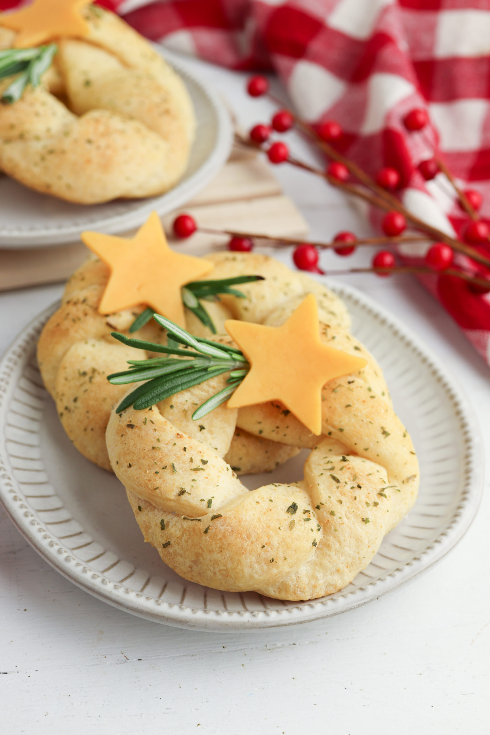 Crescent roll wreaths on a plate with rosemary sprig and cheese star