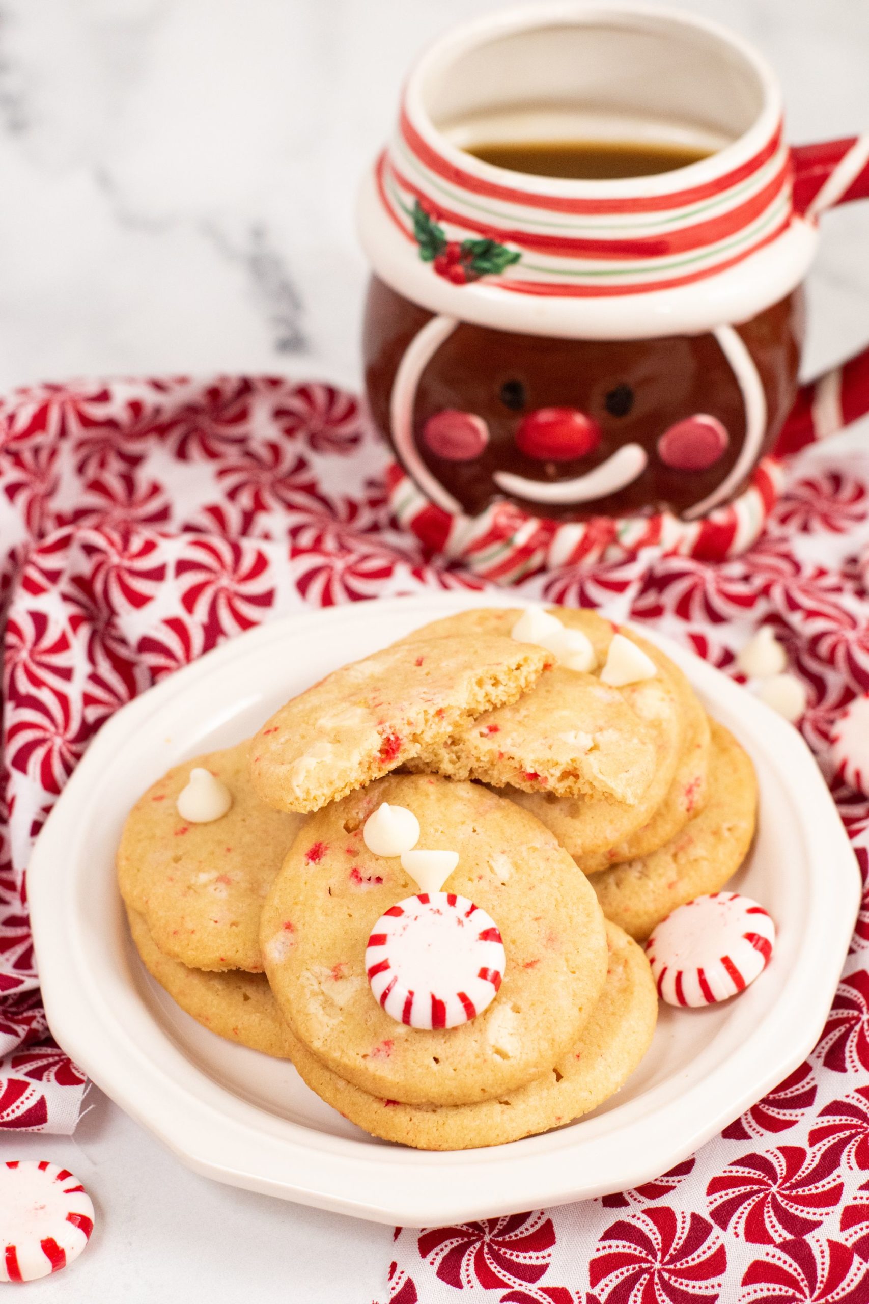 Peppermint cookies piled on a white plate with peppermint candies