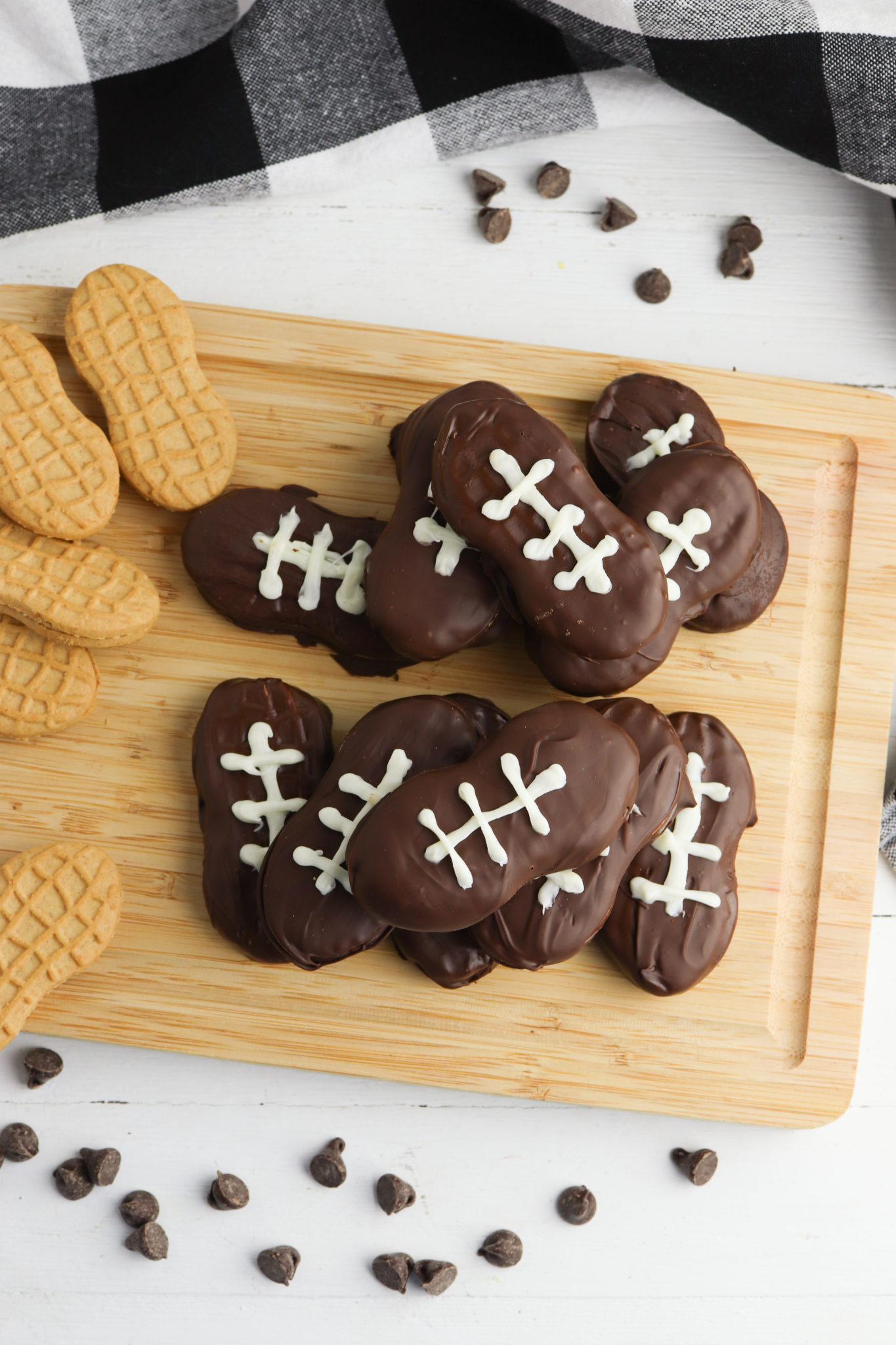 Football cookies that have bee completed and nutter butters before they have been decorated.