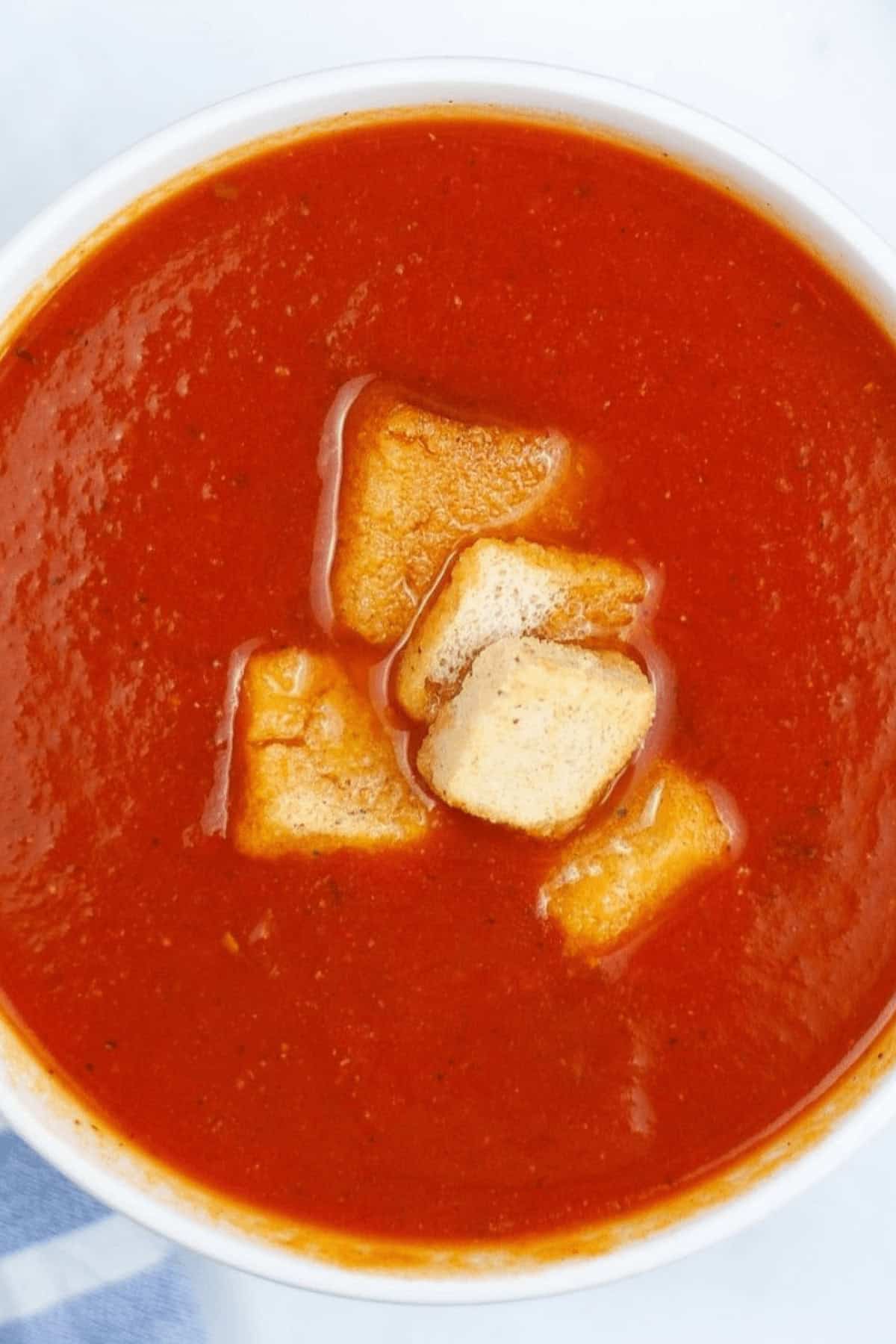 Instant Pot Tomato Soup garnished with crunchy croutons.