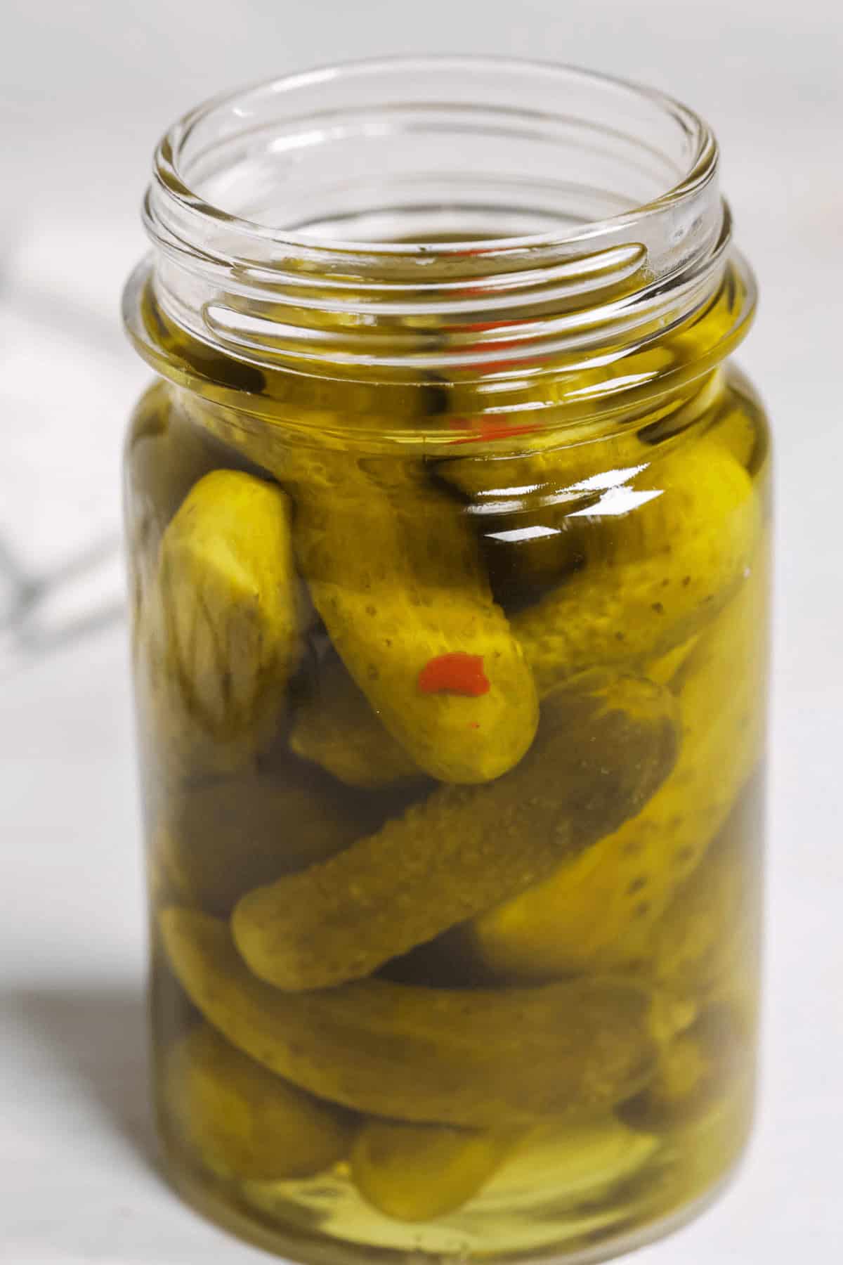 A close up on a jar of moonshine pickles.