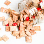 Red Velvet Chex Muddy Buddies spilling out of a mason jar.