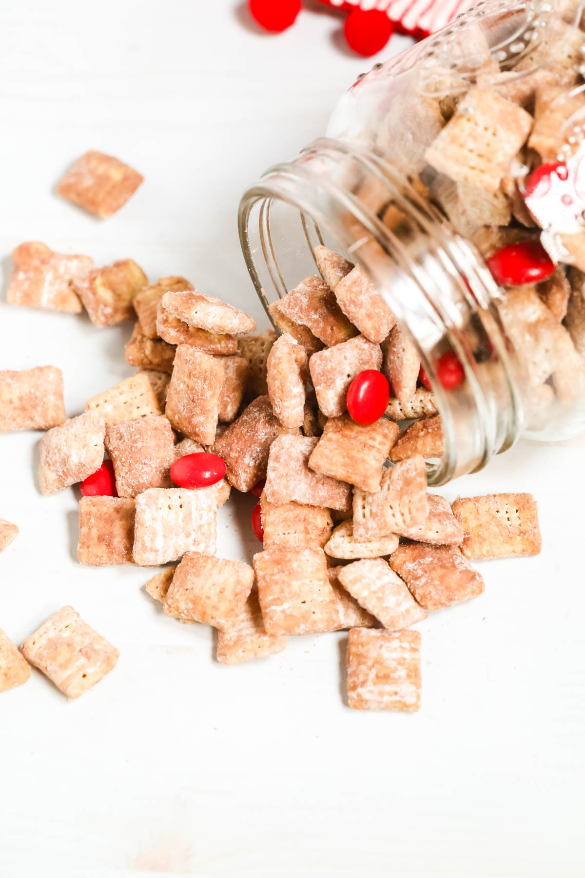 Red Velvet Chex Muddy Buddies spilling out of a mason jar.
