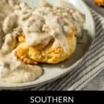 A plate of Southern-style sausage biscuits topped with rich gravy, served on a light-colored dish.