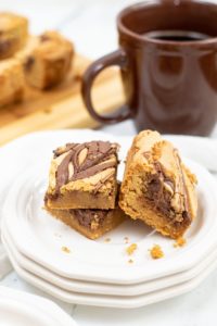 Hazelnut Brownie Blondies with a coffee cup in the background.