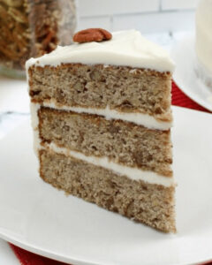 An old fashioned hummingbird cake on a white plate.
