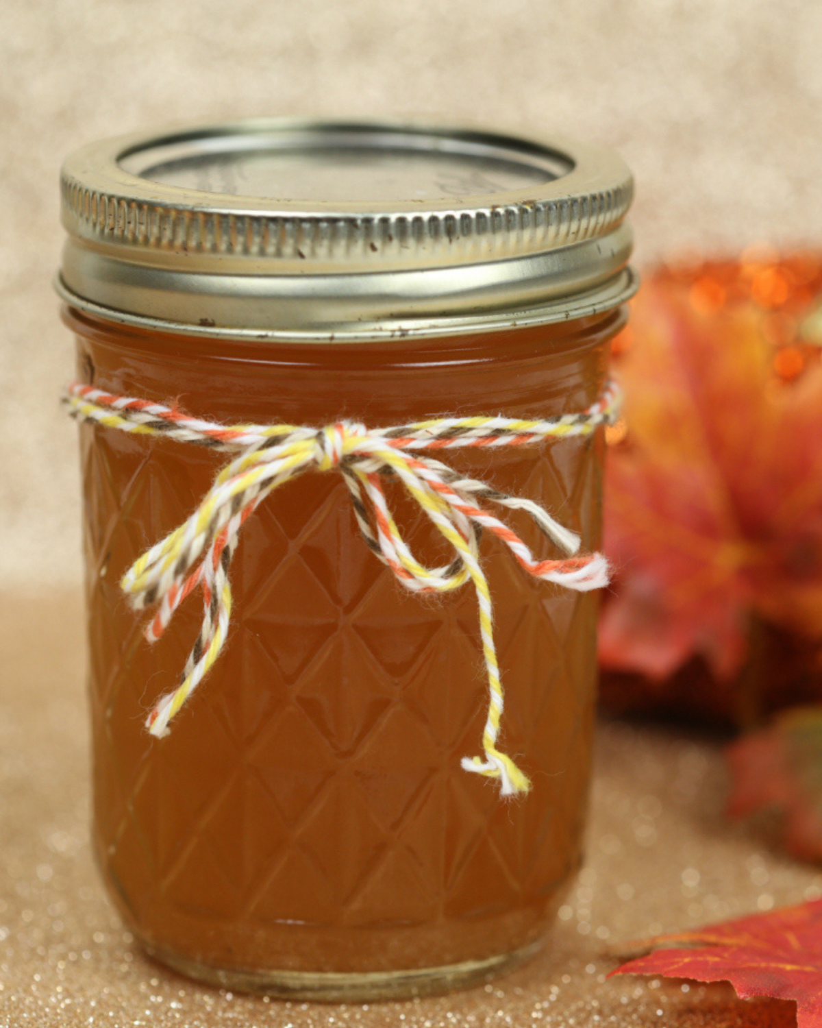 Pumpkin flavor moonshine in a jar with string around the lid.