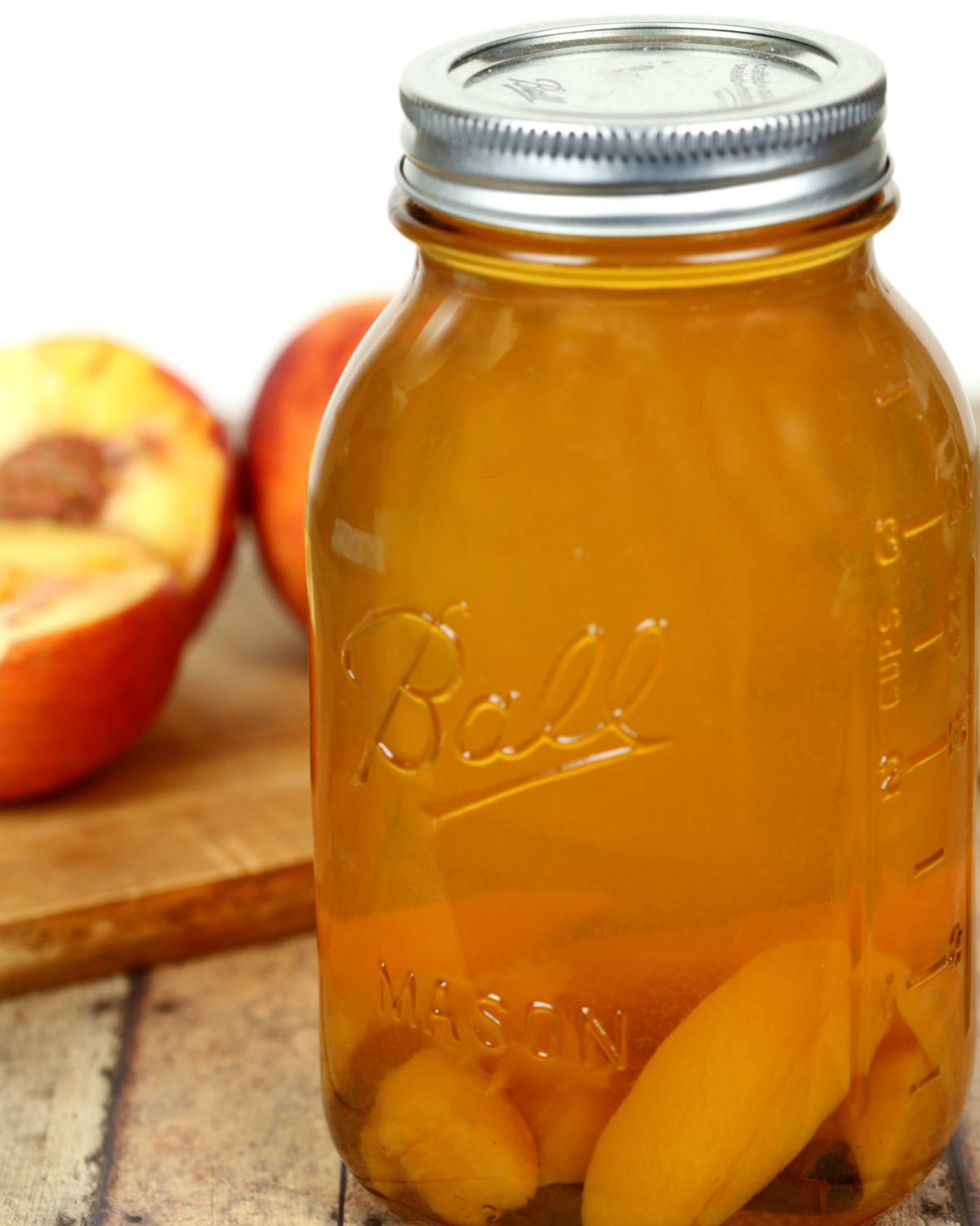 Peach moonshine recipes in a jar with sliced peaches.