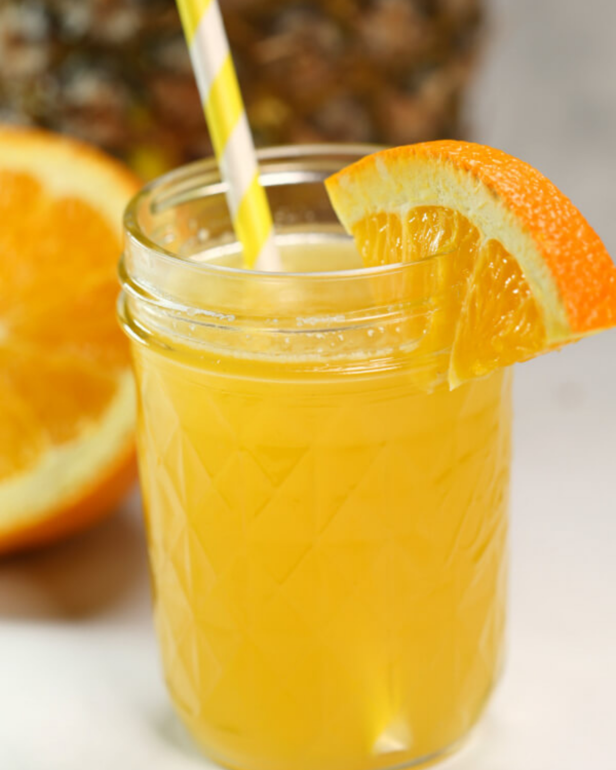 Tropical moonshine flavors in a jar with an orange slice