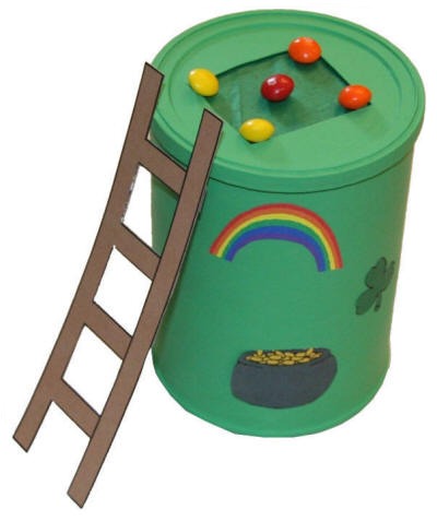 A coffee can decorated with paper rainbows and pots of gold. A paper ladder leans against the can.