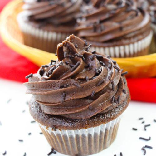 Chocolate Whip Cream Frosting on a chocolate cupcake with sprinkles around it.