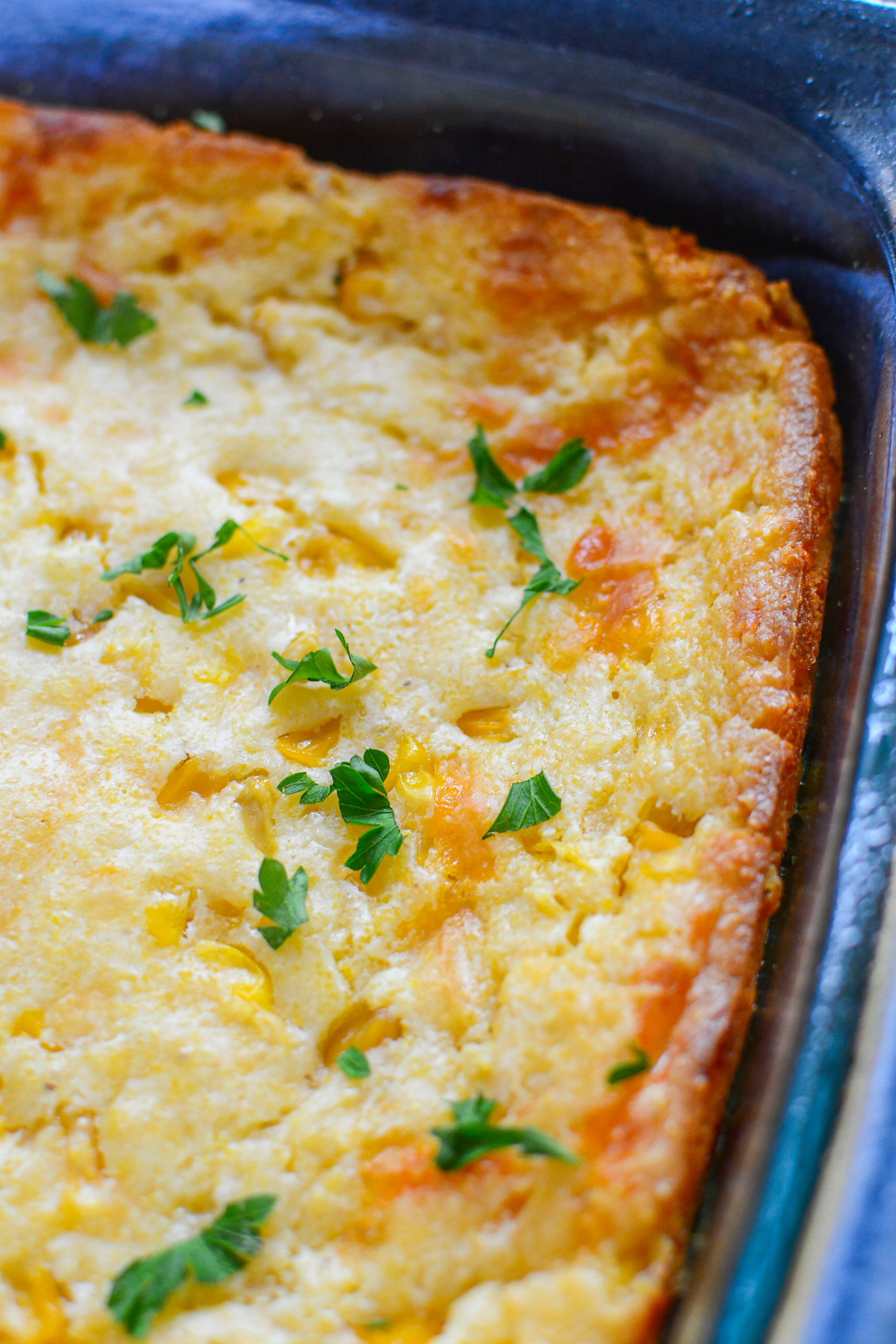  Creamy Cheese Corn Casserole topped with fresh herbs.