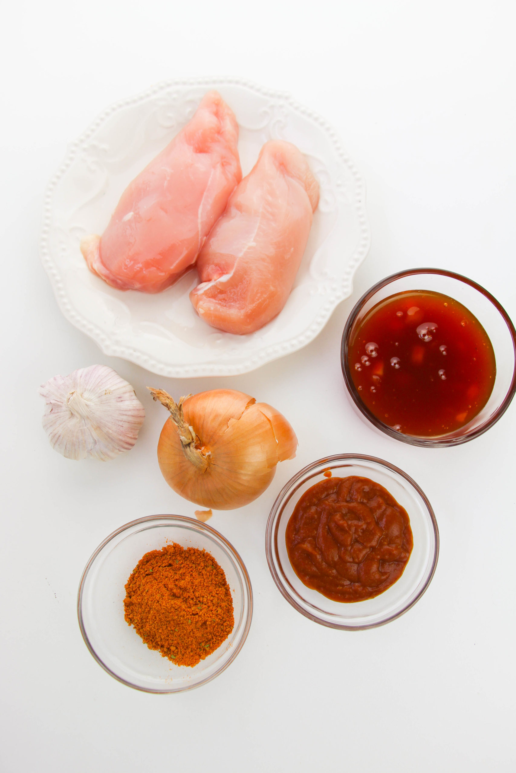 Chicken, spices and oil in bowls to make sauce.