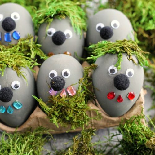 Grey colored eggs with googly eyes and faces attached.