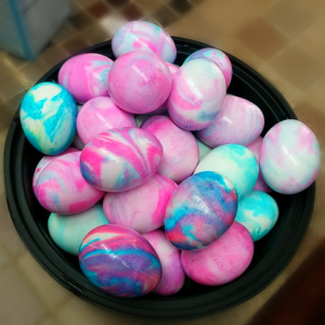 An assortment of pastel colored eggs dyed in a marble like pattern.