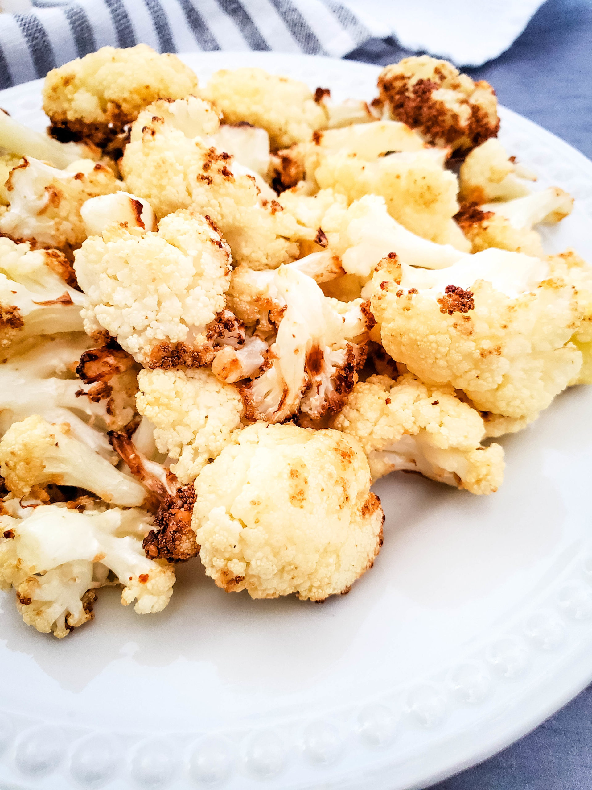 cauliflower after air frying on a white plate.