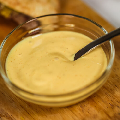 A bowl of burger sauce, the best burger sauce, on a wooden cutting board.