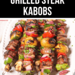 A plate of steak kabobs with vegetables, garnished with chopped herbs. A banner at the top reads "Delicious Grilled Steak Kabobs.