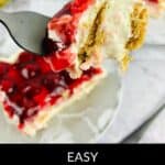 A fork holds a bite of No Bake Cherry Cheesecake above a plate, showcasing its luscious cherry topping and buttery graham cracker crust.