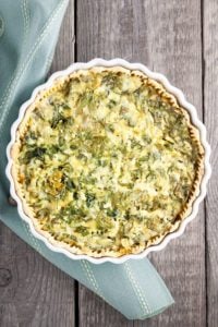 Quiche on a wood table with a blue napkin.