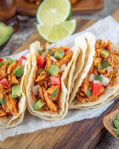 Slow Cooked Shredded Chicken Tacos. three on a white plate.