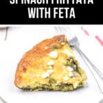 A savory slice of this Spinach Frittata Recipe, topped with crumbled feta, sits invitingly on a white plate, ready to be enjoyed with a fork.