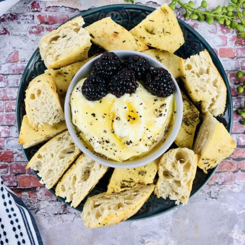 Whipped Ricotta Dip with Honey in a top shot surrounded by crusty bread.