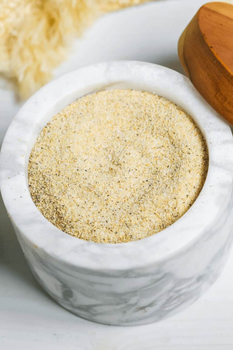 A marble container with all purpose seasoning inside.