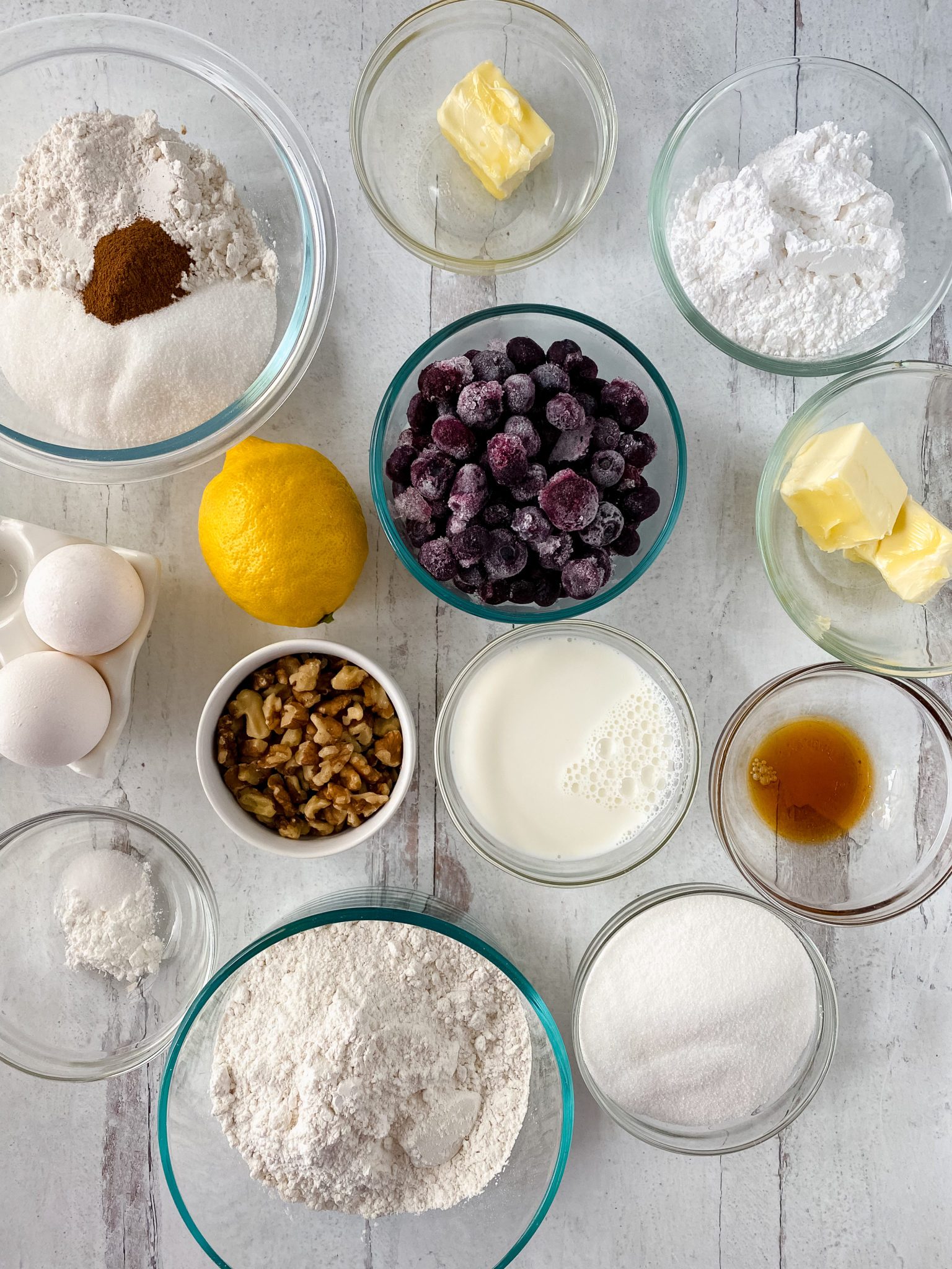 Glass dishes of blueberries, lemon zest and juice , sugar required to make the loaf.