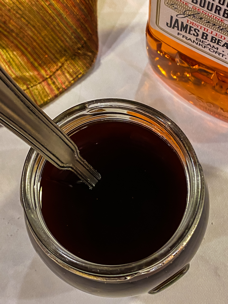 Bourbon Glaze in a mason jar with a spoon.