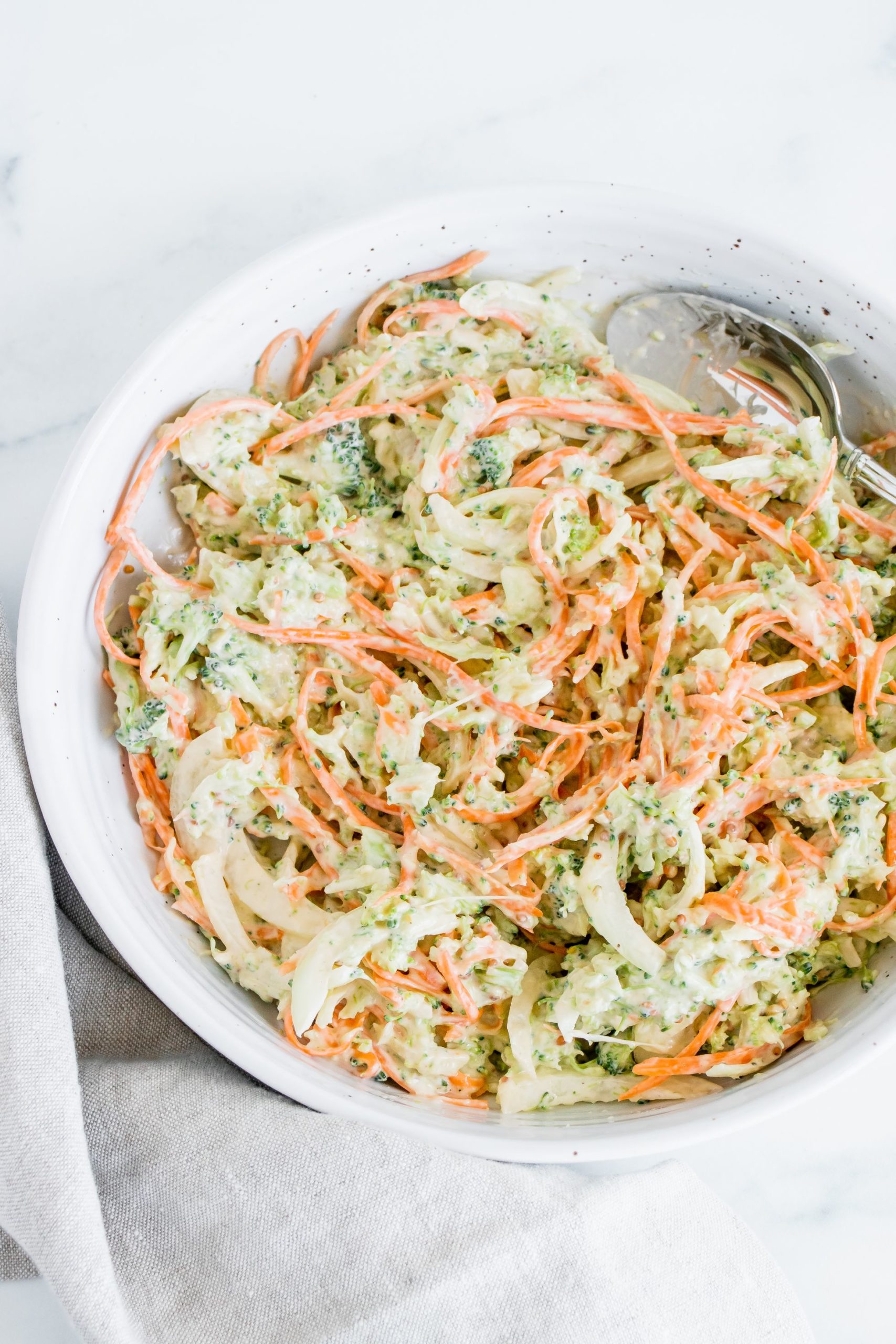 A white bowl of Broccoli Coleslaw.