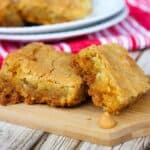 A tray of the butterscotch blondies with a wooden cutting board in front.
