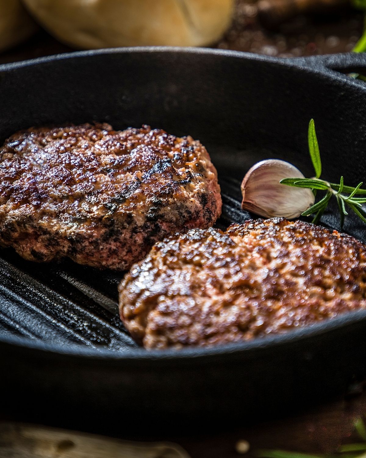 Burgers in a cast iron pan.