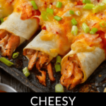 Cheesy chicken enchiladas topped with melted cheese and chopped green onions, presented on a black plate.
